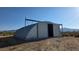 Arched metal building with sliding door, sitting on a dirt lot with mountain views at 1180 Lava Ave, Jean, NV 89019