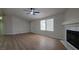 Open-concept living room with fireplace, ceiling fan, hardwood flooring, and bright windows at 1180 Lava Ave, Jean, NV 89019