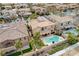 An aerial view showcases a home with a backyard pool and spa, surrounded by desert landscaping and topped with solar panels at 12116 Vista Linda Ave, Las Vegas, NV 89138