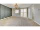 Bedroom features a decorative chandelier, carpet flooring, and sliding door for natural light at 12116 Vista Linda Ave, Las Vegas, NV 89138