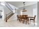 Elegant dining area with a modern light fixture, hardwood floors, and seamless integration with the staircase at 12116 Vista Linda Ave, Las Vegas, NV 89138