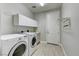 This laundry room has storage cabinets, hanging rack, and a washer and dryer at 12116 Vista Linda Ave, Las Vegas, NV 89138
