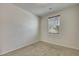 A clean, carpeted bedroom showcasing neutral paint, large window with blinds, and ample natural light at 152 Walkinshaw Ave, Las Vegas, NV 89148