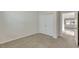 A cozy, carpeted bedroom with neutral paint, double door closet, and a glimpse of natural light from the door way at 152 Walkinshaw Ave, Las Vegas, NV 89148