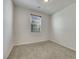 A clean, carpeted bedroom showcasing neutral paint, large window with blinds, and ample natural light at 152 Walkinshaw Ave, Las Vegas, NV 89148