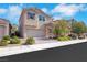 Charming two-story home featuring a brick driveway, stucco exterior, well-manicured landscaping, and an attached two-car garage at 152 Walkinshaw Ave, Las Vegas, NV 89148
