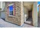 Close up of a charming home's exterior featuring stone veneer, window shutters, and a covered entryway at 152 Walkinshaw Ave, Las Vegas, NV 89148