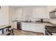 Modern kitchen featuring white cabinets, granite countertops, stainless steel appliances, and wood-look flooring at 1611 Prairie Fields Ct, Las Vegas, NV 89115