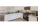 Bright kitchen with stainless steel appliances, granite countertops, white cabinets, and wood-look flooring at 1611 Prairie Fields Ct, Las Vegas, NV 89115
