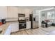 Spacious kitchen featuring stainless steel appliances, granite countertops, white cabinets, and an adjacent living area at 1611 Prairie Fields Ct, Las Vegas, NV 89115