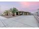 Inviting single-story home with palm trees, desert landscaping and concrete driveway at 1628 Izabella Ave, Las Vegas, NV 89169