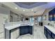 Open kitchen with quartz counters, blue cabinets, and a view to the living and dining areas at 200 Teller St, Henderson, NV 89074