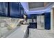 Well-lit kitchen featuring stainless steel refrigerator, quartz countertops, and navy blue cabinetry at 200 Teller St, Henderson, NV 89074
