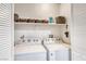 Laundry room with white appliances, overhead storage shelves and ample space at 200 Teller St, Henderson, NV 89074