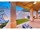 Charming covered patio with outdoor furniture and decorative string lights overlooks a lush green space for relaxing and entertaining at 200 Teller St, Henderson, NV 89074