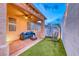 Cozy covered patio with plush seating, artificial turf, and decorative string lights creates a relaxing outdoor retreat at 200 Teller St, Henderson, NV 89074