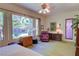 Sunlit bedroom with a view of tropical plants, chair, and a matching side table with drawers at 2026 Poppywood Ave, Henderson, NV 89012