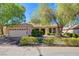 Charming single-story home with a well-manicured front yard, mature trees, and a two-car garage at 2026 Poppywood Ave, Henderson, NV 89012