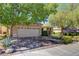 Attractive home featuring a two-car garage, complemented by mature trees and an American flag at 2026 Poppywood Ave, Henderson, NV 89012