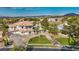 Expansive aerial view of a two-story home with a manicured lawn, a circular driveway, and lush landscaping at 2058 Troon Dr, Henderson, NV 89074