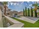 Well-maintained backyard with artificial grass, privacy landscaping, and water feature at 2058 Troon Dr, Henderson, NV 89074