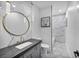 Elegant bathroom featuring marble walls, modern vanity with a gold-trimmed mirror, and pendant lights at 2058 Troon Dr, Henderson, NV 89074