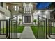 Dramatic entrance showcasing a paved walkway, modern black entry doors, lush landscaping, and large windows at 2058 Troon Dr, Henderson, NV 89074