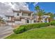 Stunning two-story home showcasing a well-manicured lawn, mature palm trees, and a circular driveway at 2058 Troon Dr, Henderson, NV 89074
