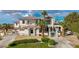 Stunning two-story home boasting a red tile roof, a large front lawn, palm trees, and a circular driveway at 2058 Troon Dr, Henderson, NV 89074
