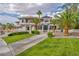 Attractive two-story home featuring a red tile roof, lush landscaping, and a circular driveway under a bright sky at 2058 Troon Dr, Henderson, NV 89074