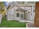 View of home's backyard area with an exterior door, lush green lawn and brick wall at 2058 Troon Dr, Henderson, NV 89074