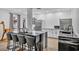 Modern kitchen featuring a marble island with seating, stainless steel appliances, and textured white wall at 2058 Troon Dr, Henderson, NV 89074