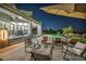 Inviting backyard with a covered patio, cozy seating areas, and a view of the sparkling swimming pool at night at 2058 Troon Dr, Henderson, NV 89074
