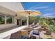 A backyard featuring an outdoor dining area under a large umbrella, surrounded by desert landscaping at 2331 Galilean Moon St, Henderson, NV 89044