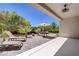 A peaceful backyard featuring a covered patio and lounge chairs, surrounded by lush landscaping at 2331 Galilean Moon St, Henderson, NV 89044