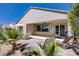 An outdoor patio featuring desert landscaping with lounge chairs and a table with chairs at 2331 Galilean Moon St, Henderson, NV 89044
