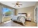 Bright bedroom featuring a ceiling fan, wood-look flooring, and large windows with neighborhood views at 2331 Galilean Moon St, Henderson, NV 89044
