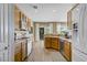 Bright kitchen with wooden cabinetry, tile floors, and a view to the backyard dining area at 2331 Galilean Moon St, Henderson, NV 89044