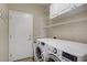 Clean and functional laundry room with shelving and modern washer and dryer units at 2331 Galilean Moon St, Henderson, NV 89044