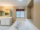 Bright bathroom featuring a soaking tub, dual sink vanity, and a window for natural light at 268 Copper Glow Ct, Henderson, NV 89074