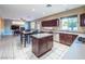 Open kitchen with granite counters, stainless appliances, island, and view into the dining and living area at 268 Copper Glow Ct, Henderson, NV 89074