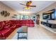 Cozy living room with a large sectional sofa, tile floors, and a ceiling fan at 268 Copper Glow Ct, Henderson, NV 89074