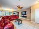 Inviting living room featuring a plush red sofa, tile flooring, and a wall-mounted TV at 268 Copper Glow Ct, Henderson, NV 89074