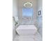 Bright bathroom features a modern tub, sleek fixtures, and elegant marble-like tile at 2891 S Rainbow Ave, Pahrump, NV 89048