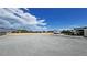 Vast gravel lot, fenced in, with recreational vehicle parked and an attached covered patio space at 2891 S Rainbow Ave, Pahrump, NV 89048