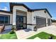 Close up of a beautiful single-story home with an iron gate entry, synthetic grass accents, and a three-car garage at 2891 S Rainbow Ave, Pahrump, NV 89048