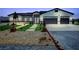 Charming single-story home with desert landscaping, synthetic grass accents, and a three-car garage at 2891 S Rainbow Ave, Pahrump, NV 89048