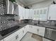 Bright kitchen featuring white cabinets, stainless steel appliances, and decorative backsplash at 2891 S Rainbow Ave, Pahrump, NV 89048
