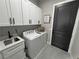 Clean, modern laundry room featuring white cabinets and black hardware at 2891 S Rainbow Ave, Pahrump, NV 89048