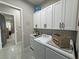 Bright laundry room with white cabinets, black hardware, and modern appliances at 2891 S Rainbow Ave, Pahrump, NV 89048